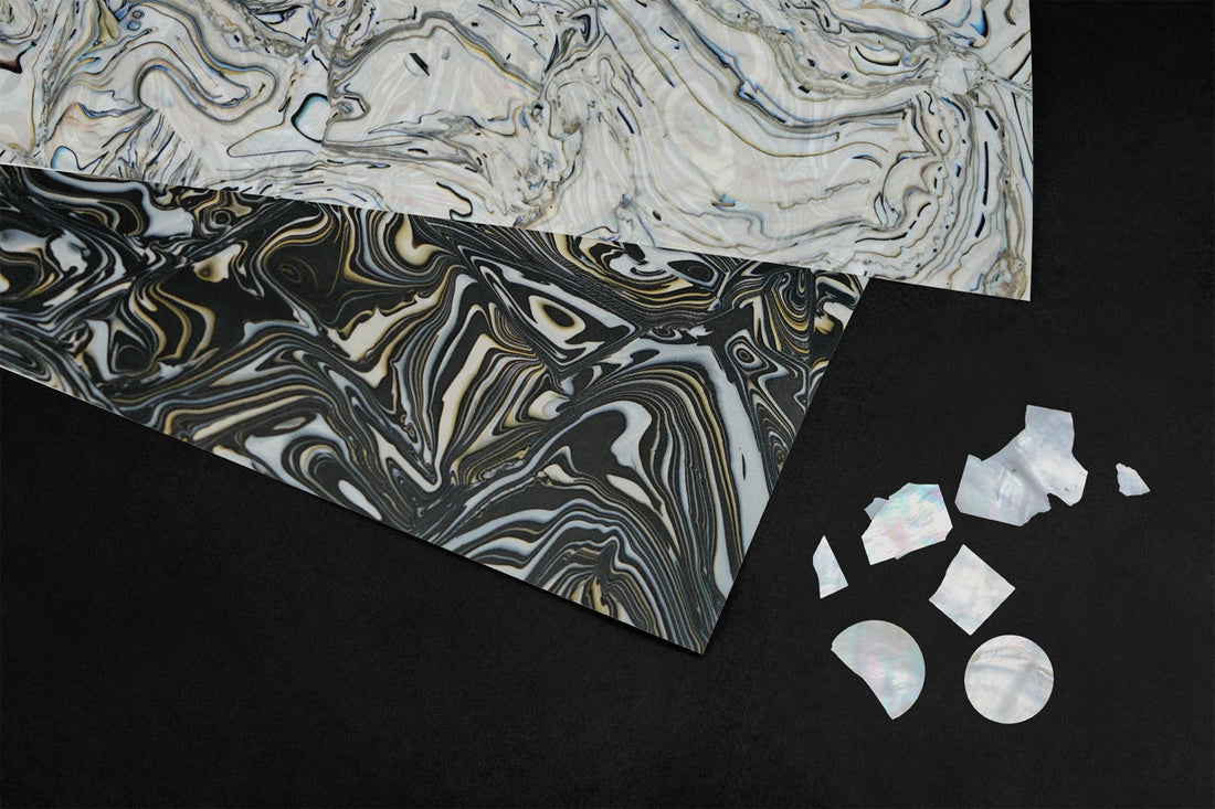 Marbled Materik surface sheets and mother-of-pearl material samples on a black background