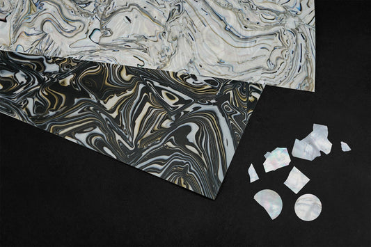 Marbled Materik surface sheets and mother-of-pearl material samples on a black background